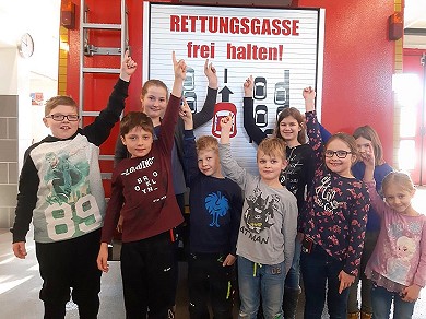 Die Mädchen und Buben der Weinberger Kinderfeuerwehr freuen sich über die neue Heckbeschriftung des Löschfahrzeugs. (Foto: Katharina Nargang)