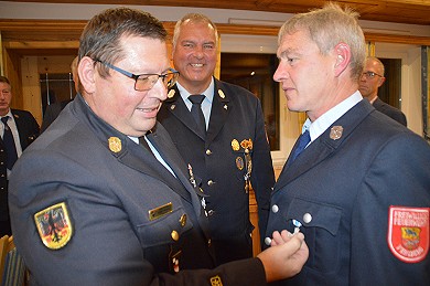 KBI Holger Frohwieser heftet Klaus Lehr das Feuerwehr-Ehrenabzeichen in Silber für 25 Jahre aktiven Dienst in der Feuerwehr an, im Beisein von KBM Albert Binder